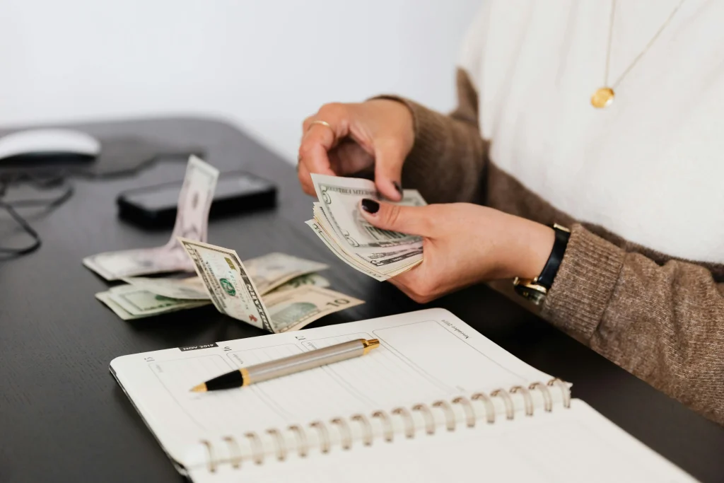 una figura femminile mentre conta dei dollari
